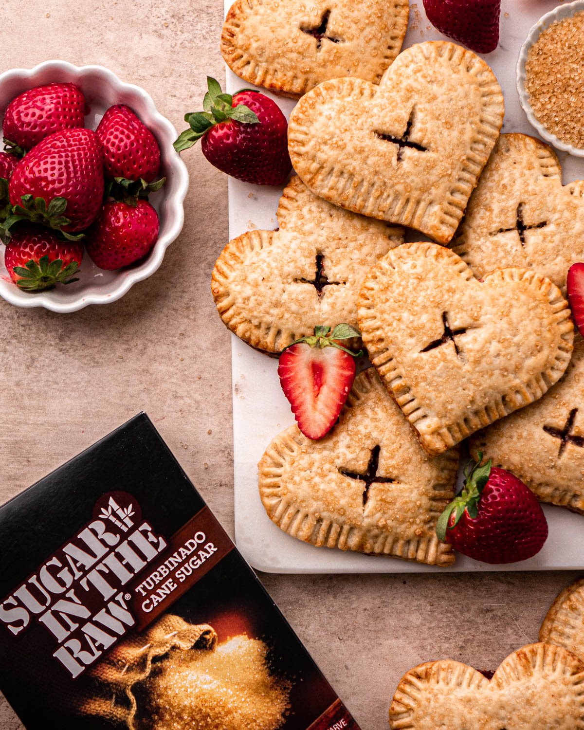 strawberry hand pies on board with Sugar In The Raw box