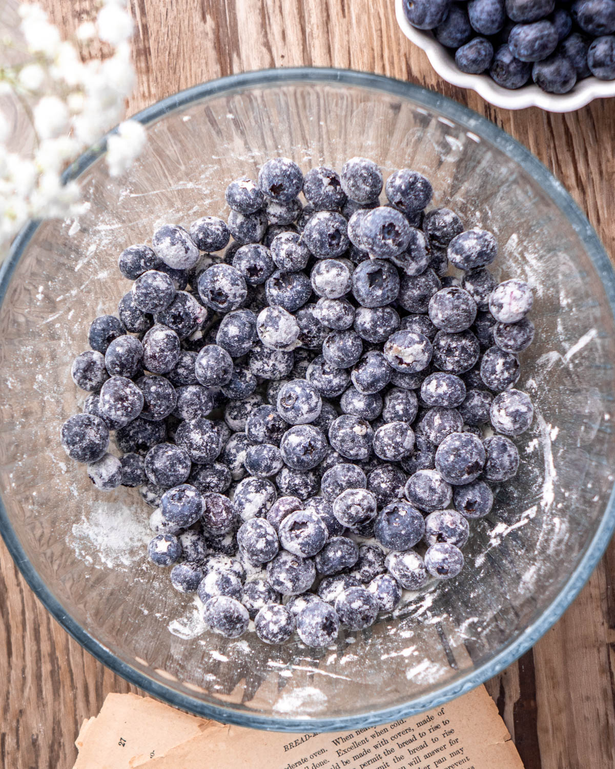Small glass bowl with flour coated blueberries