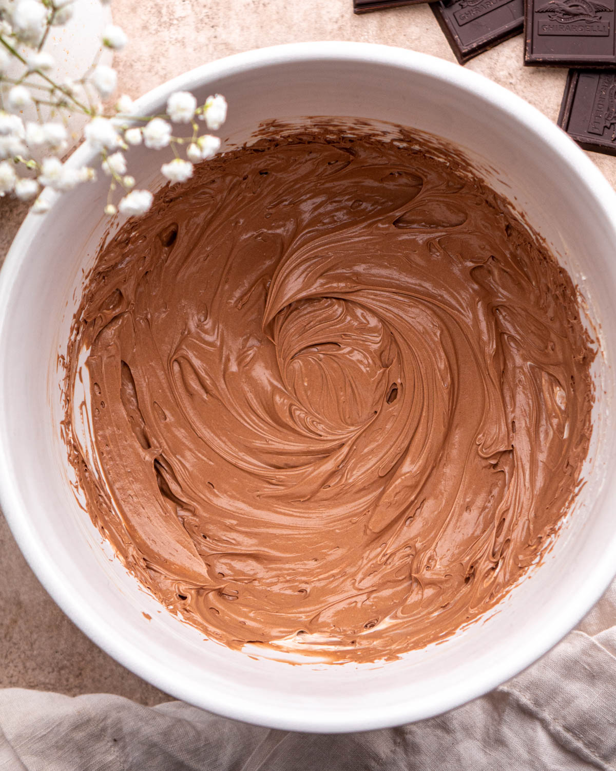 whipped butter and melted chocolate mixed together in large white bowl