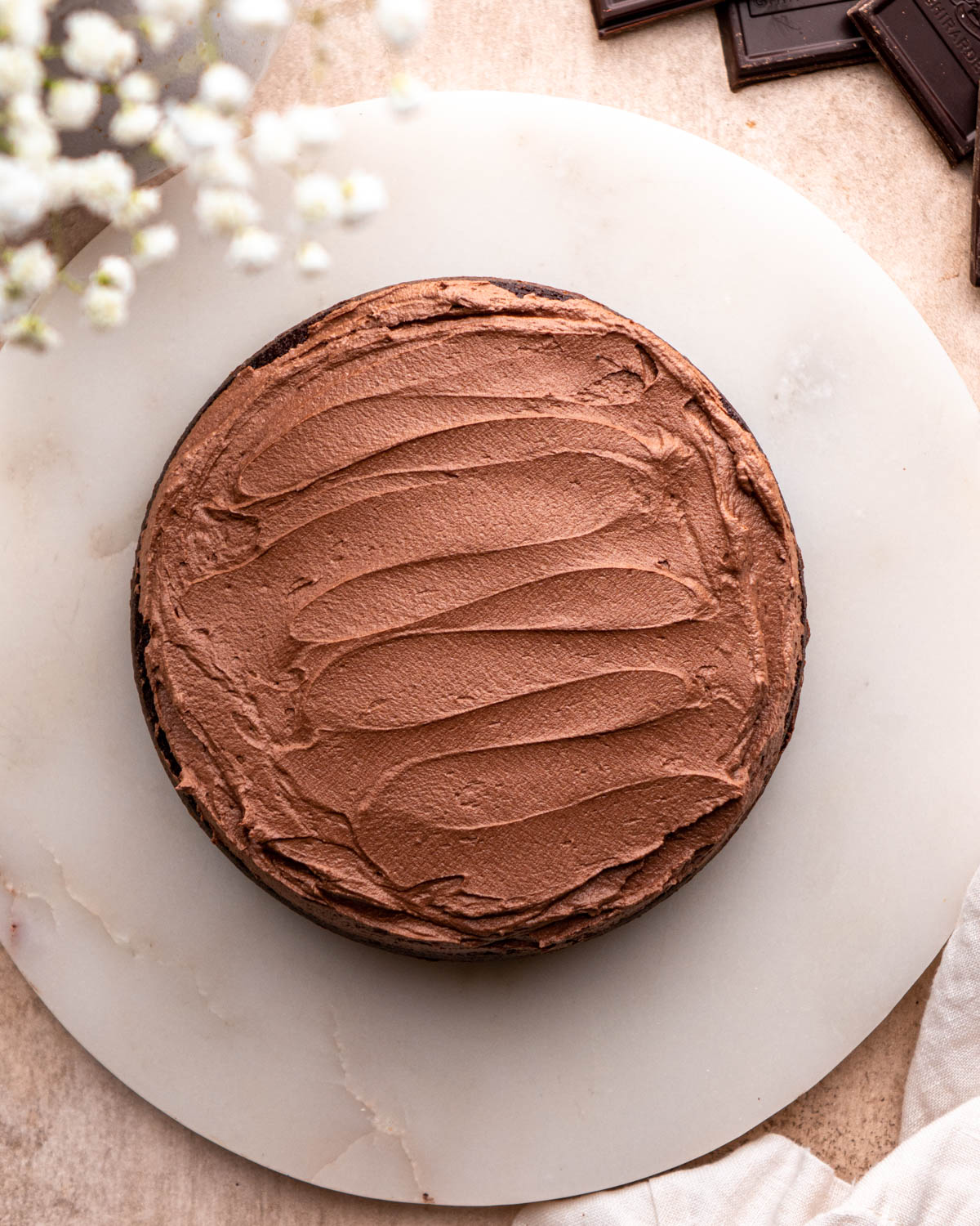 chocolate frosting spread on cake layer