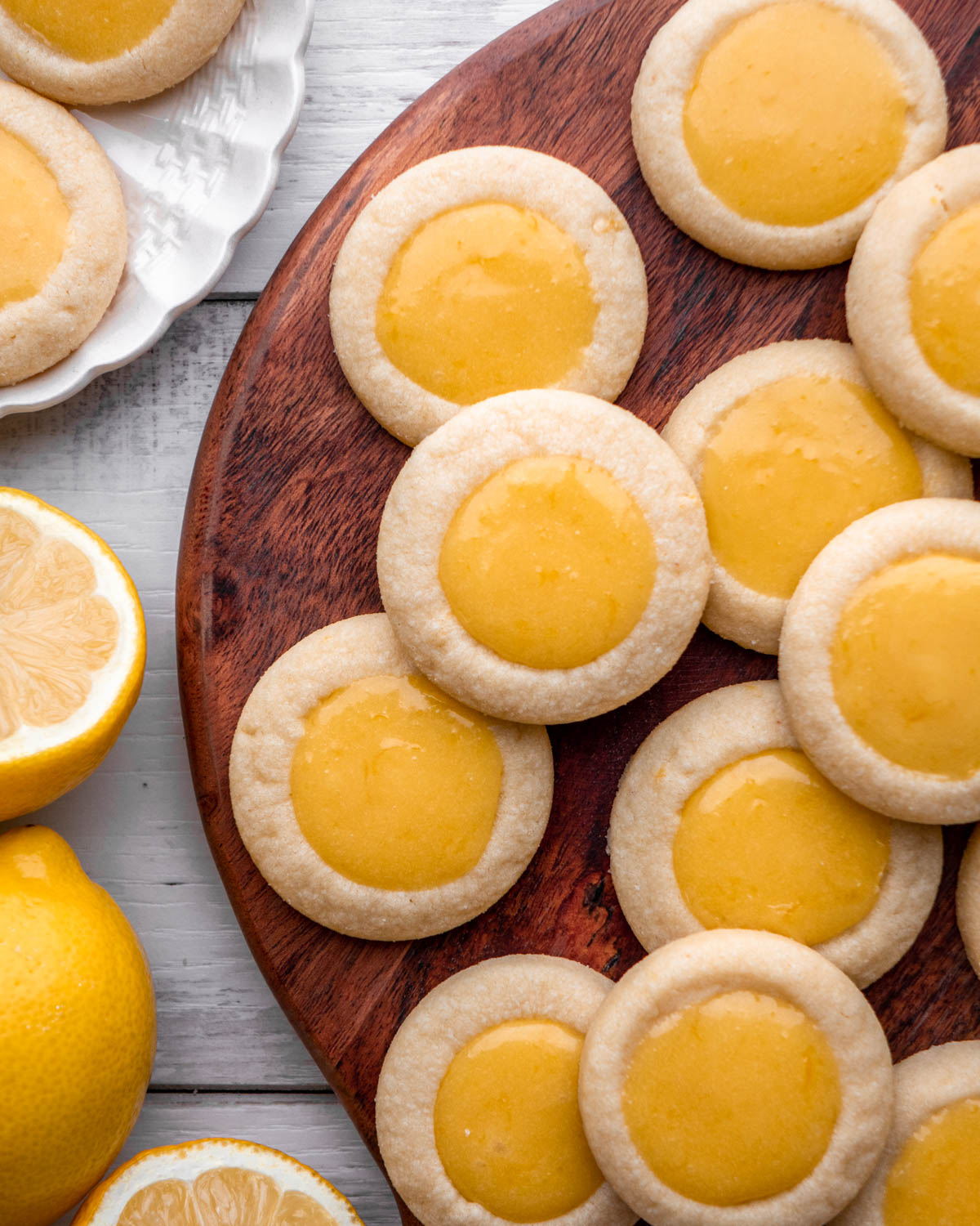 lemon curd cookies grouped together on wood board 