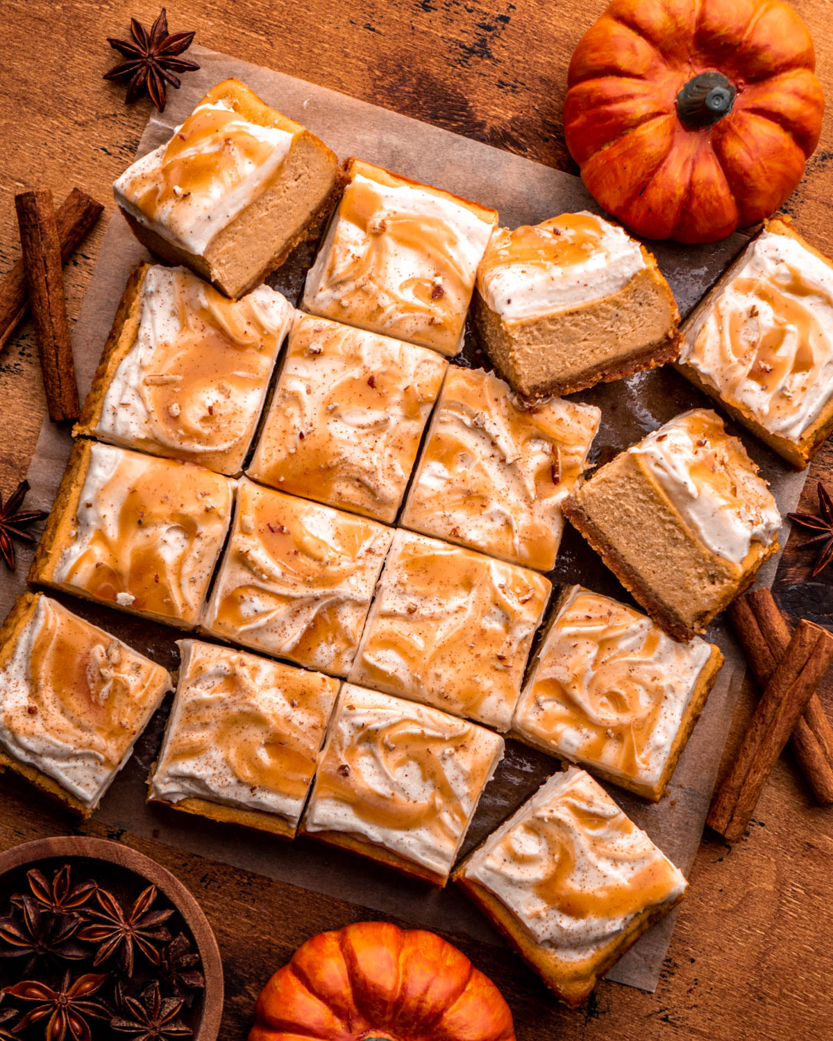 pumpkin cheesecake bars sliced into 16 bars and arranged on parchment paper