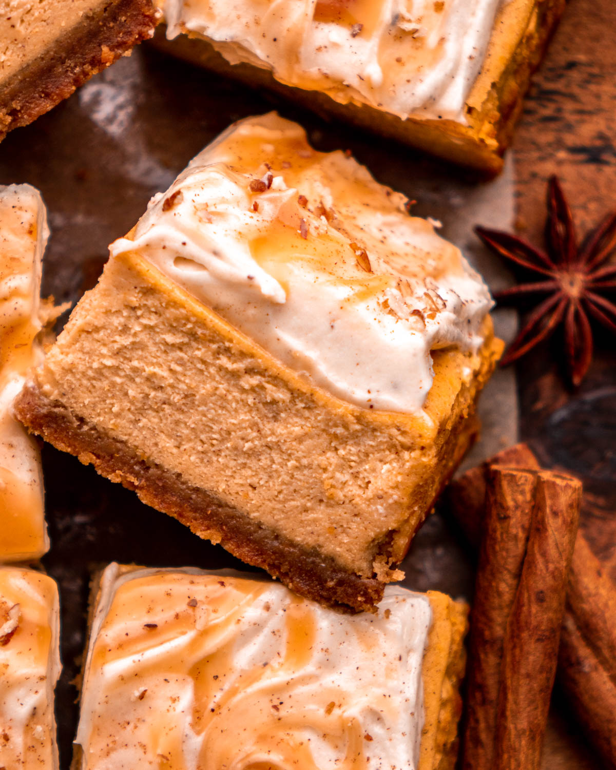 pumpkin cheesecake bar arranged on its side on parchment paper