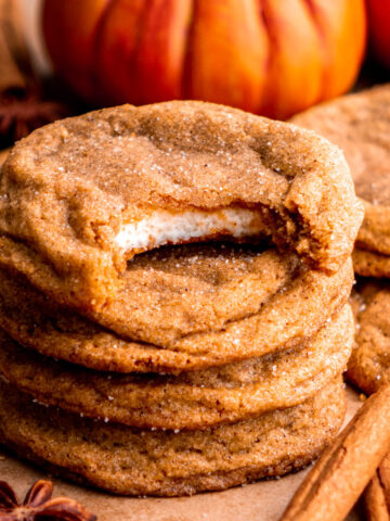 stack of pumpkin cheesecake cookies, top cookie with a bite taken out