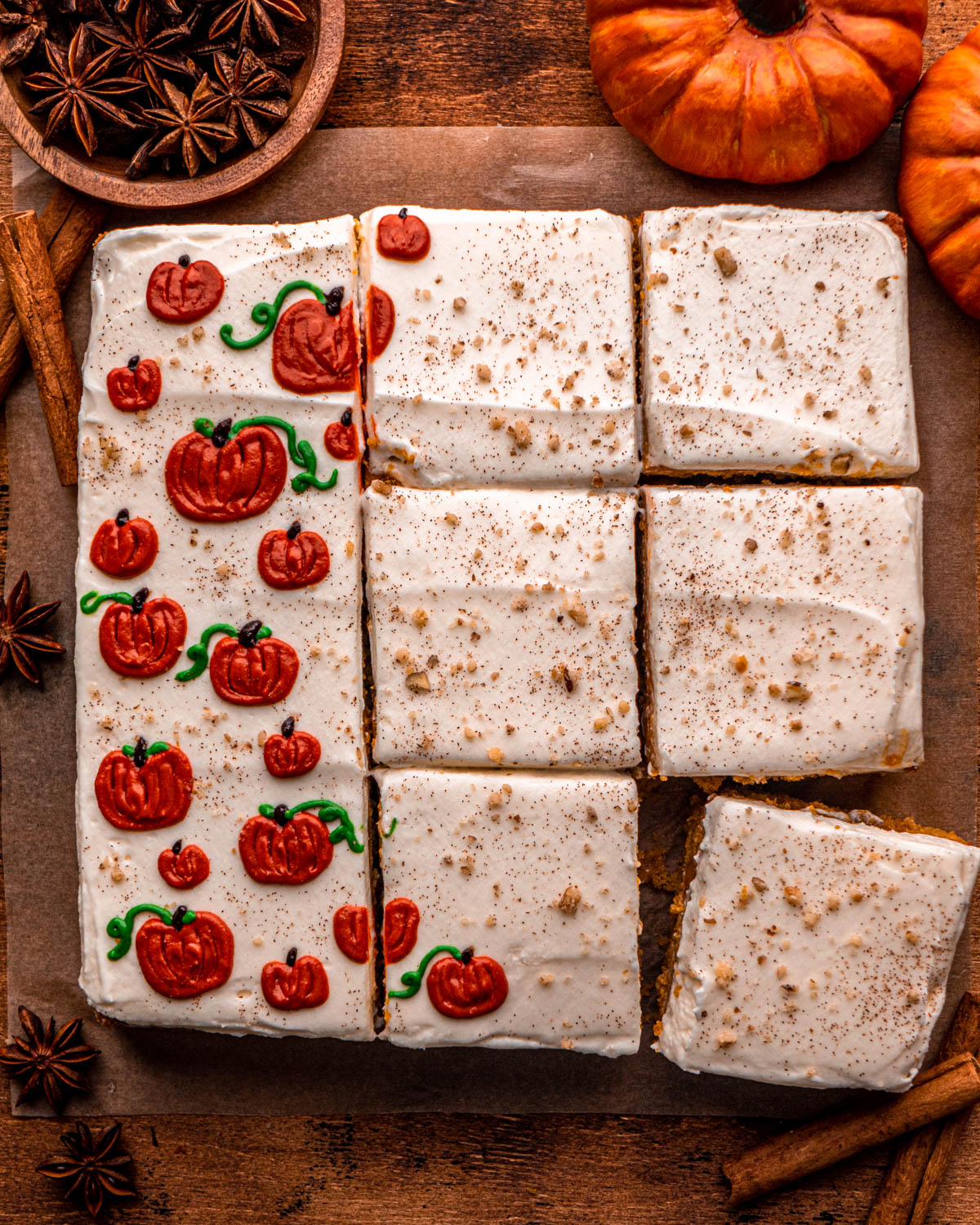 pumpkin poke cake cut into slices, decorated with little pumpkins