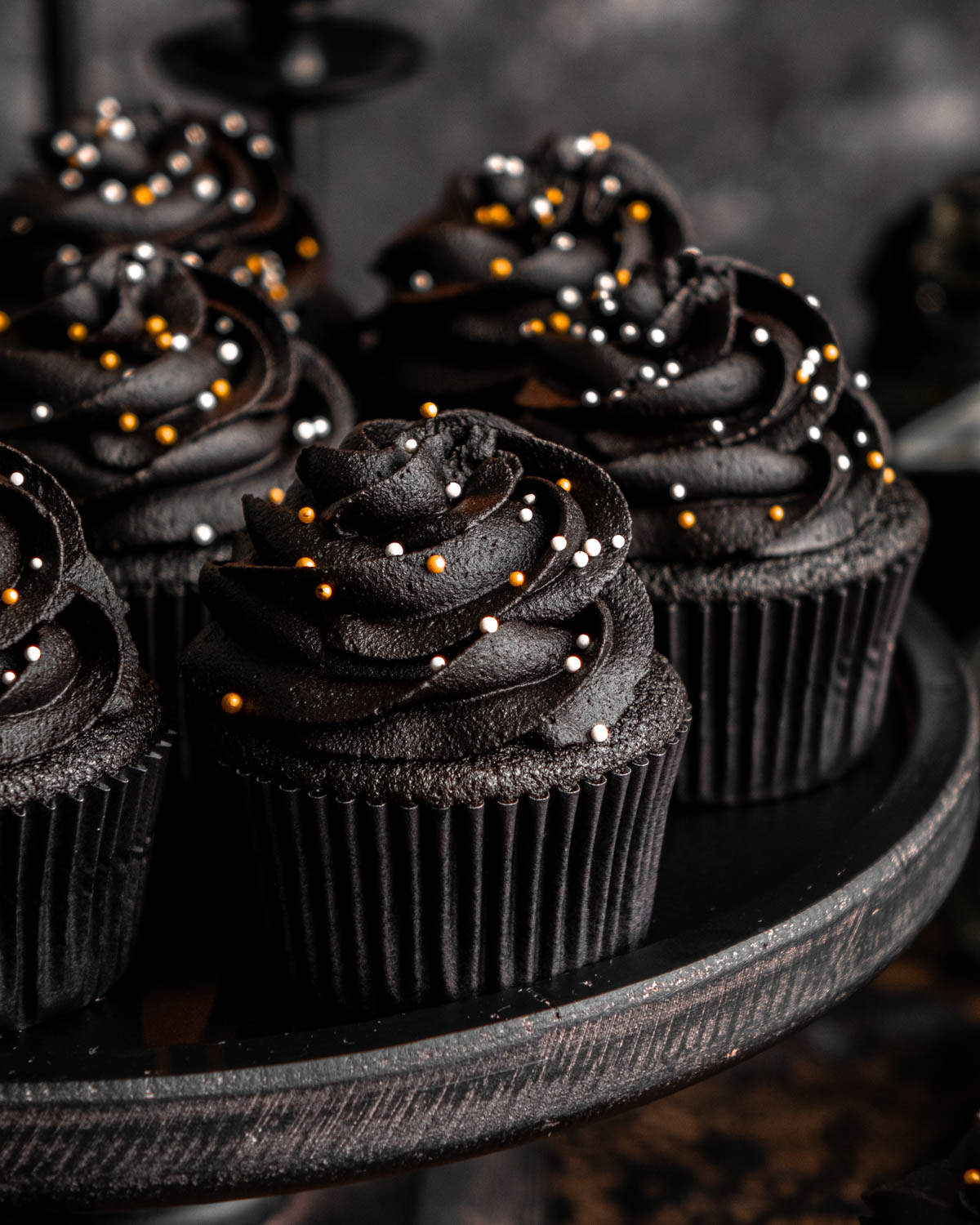 close up of black velvet cupcakes on a black cake stand