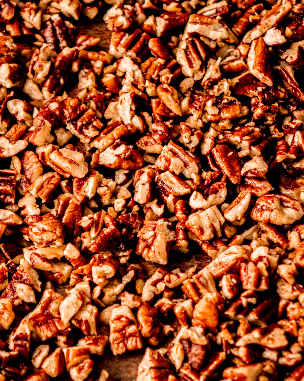 buttered pecans cooling on parchment paper