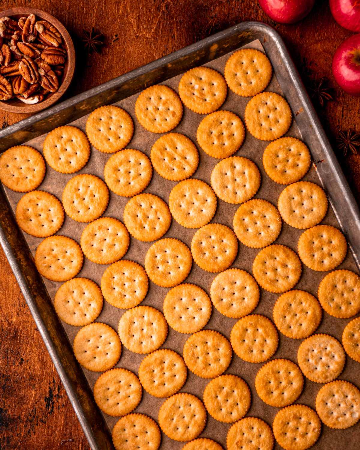 Ritz crackers arranged on parchment paper lined baking sheet