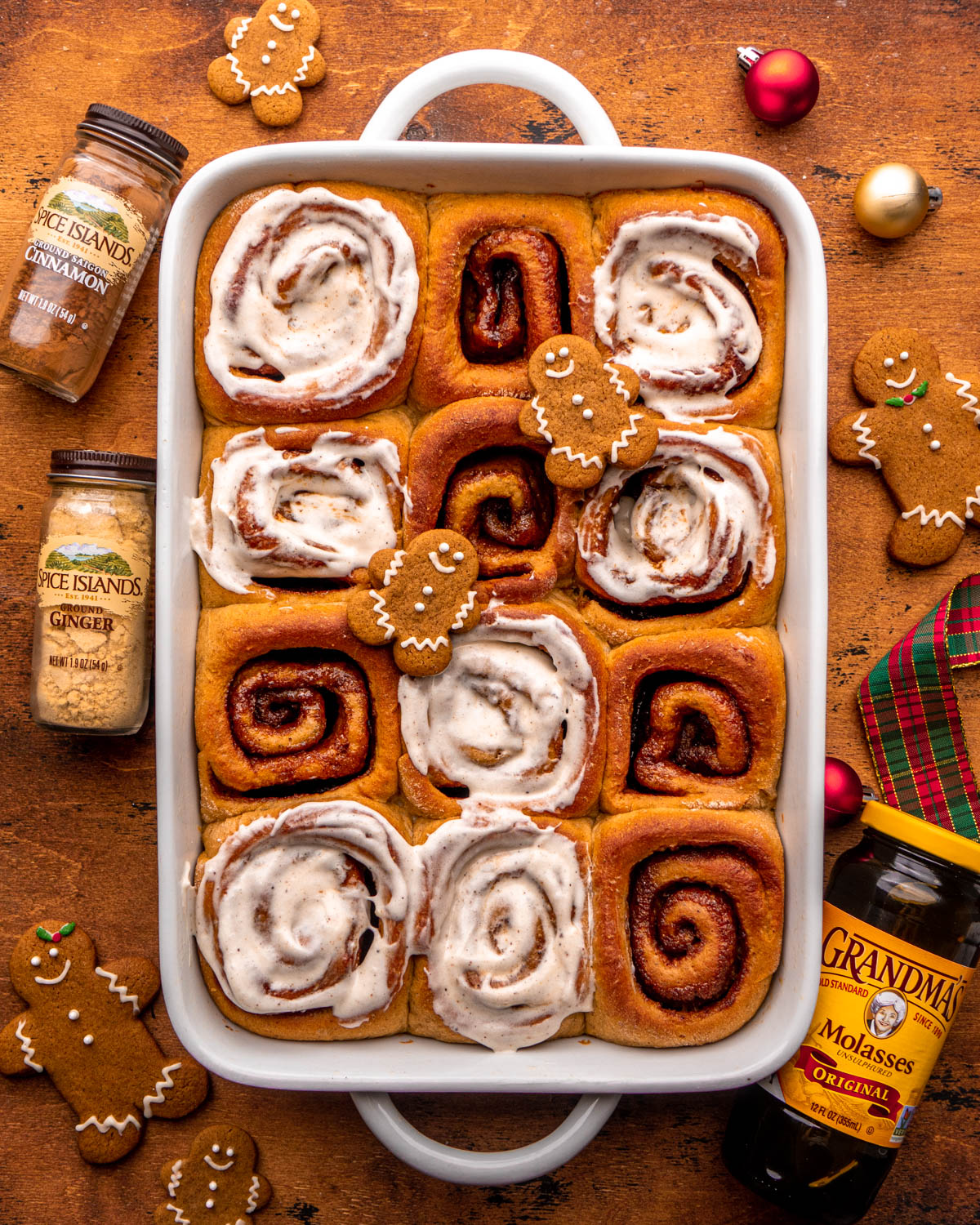 rolls with icing on top with molasses and spice bottles around