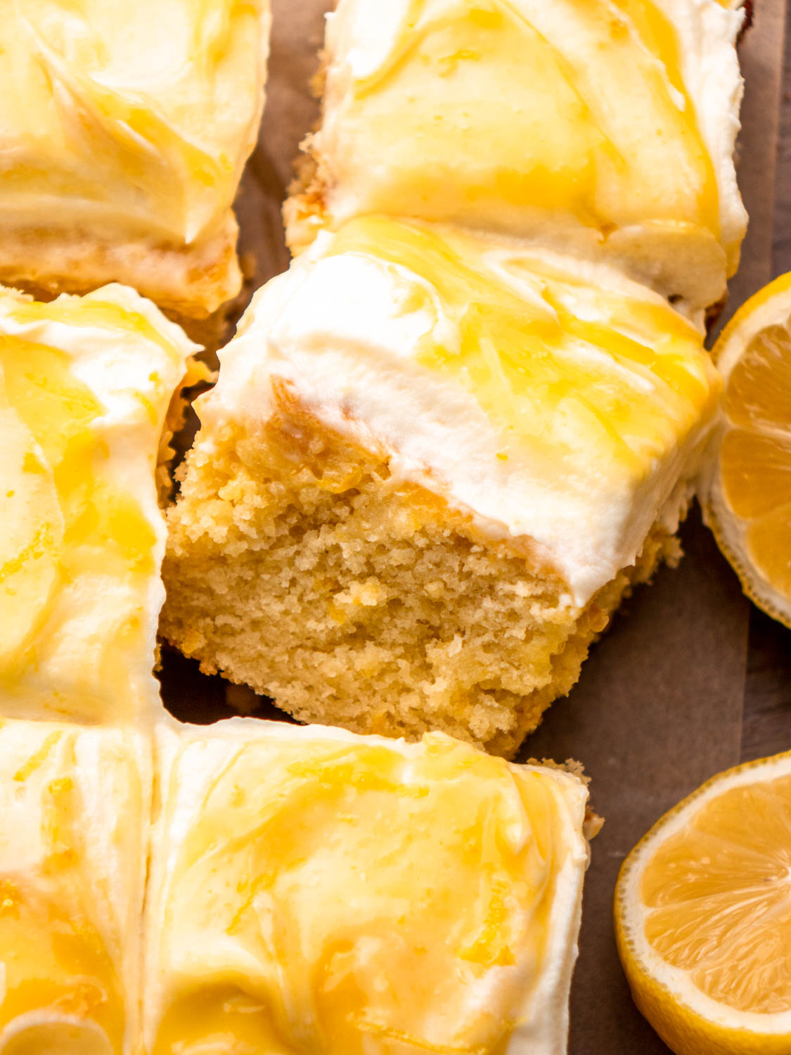 lemon curd cake on parchment paper with lemons around